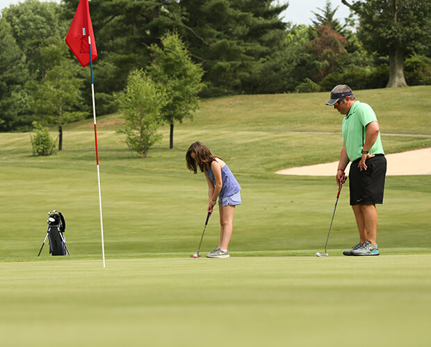 dad and daughter on the golf course