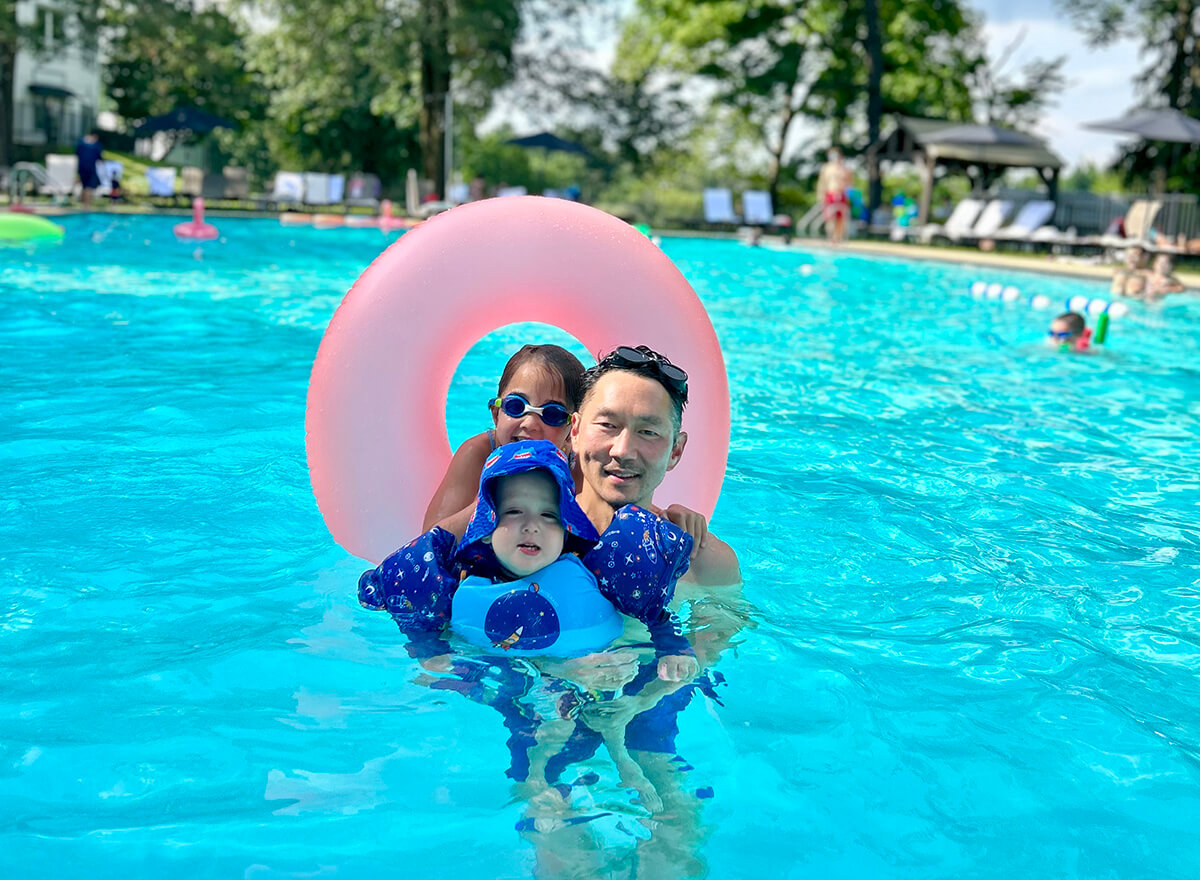 family on floaties in the pool